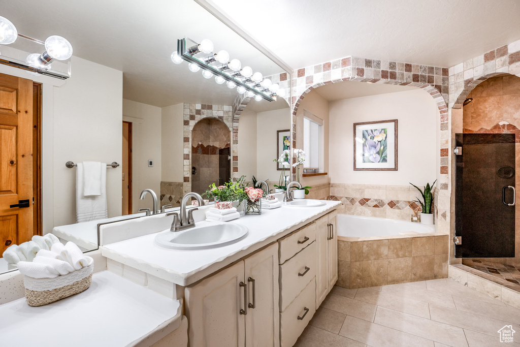 Full bathroom featuring a sink, a bath, a stall shower, and tile patterned floors
