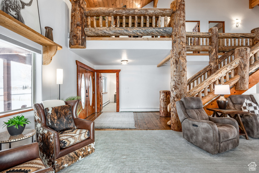 Living room with stairway, a high ceiling, and wood finished floors