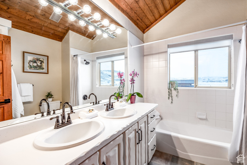 Bathroom featuring double vanity, a sink, lofted ceiling, and wooden ceiling