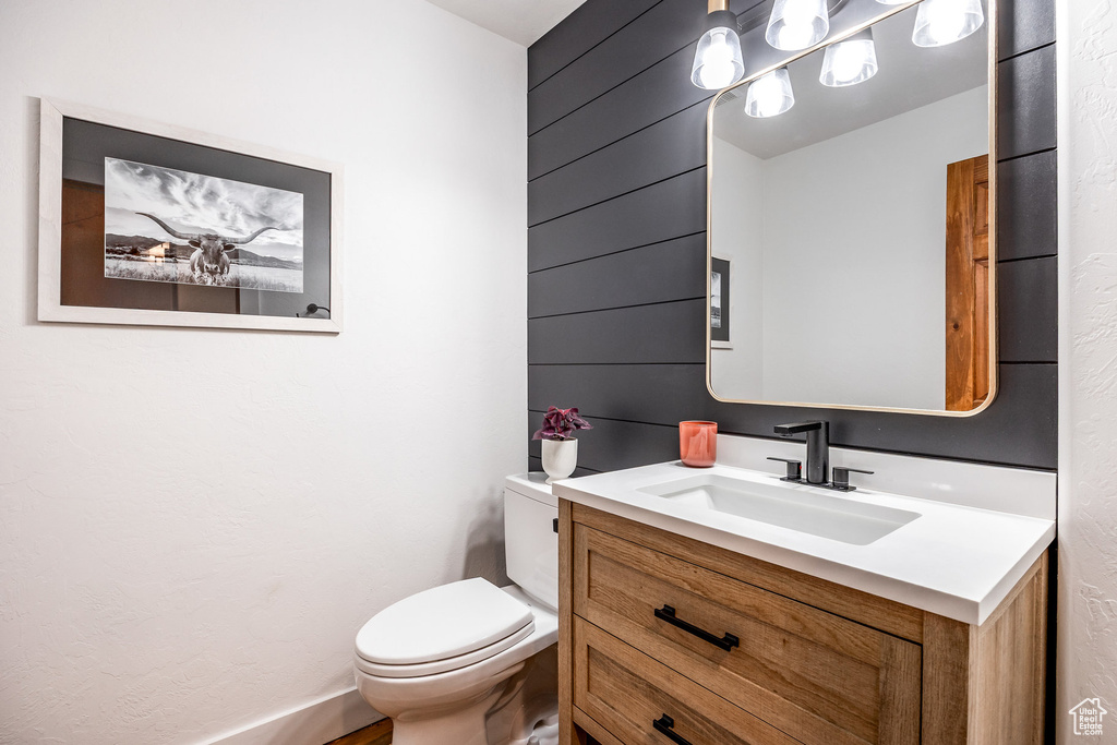 Half bathroom featuring vanity and toilet
