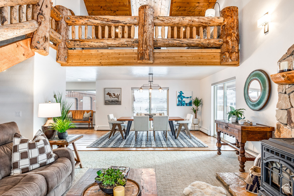 Living room featuring a wood stove, wood finished floors, and a towering ceiling