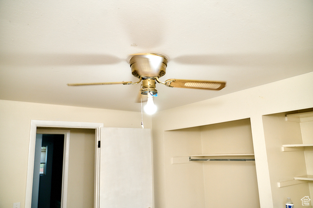 Unfurnished bedroom with ceiling fan and a closet