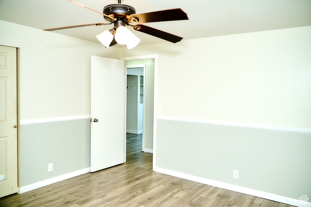 Unfurnished bedroom with light wood-style floors, baseboards, and a ceiling fan