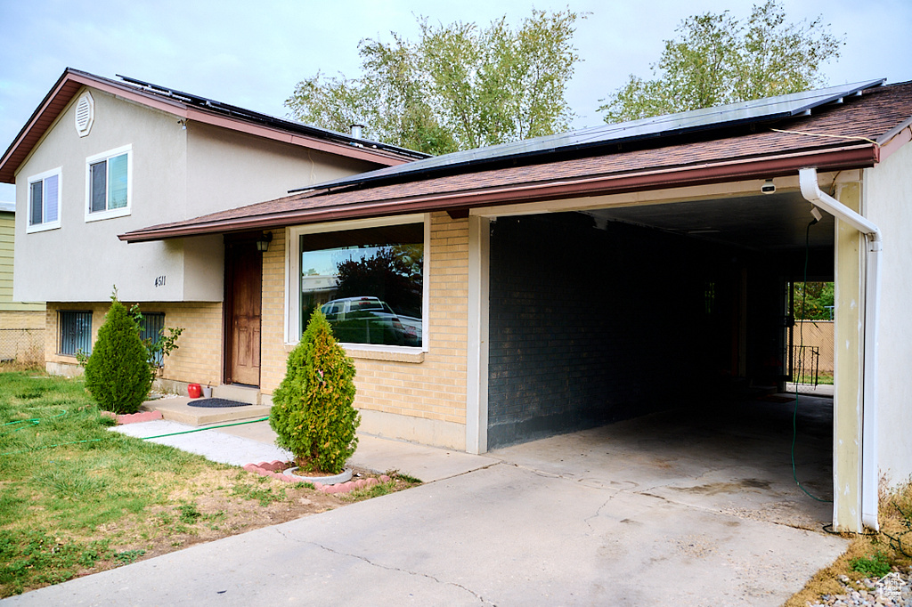 Tri-level home with a garage, brick siding, and driveway