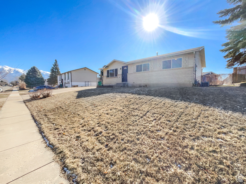 View of front of home featuring brick siding and fence