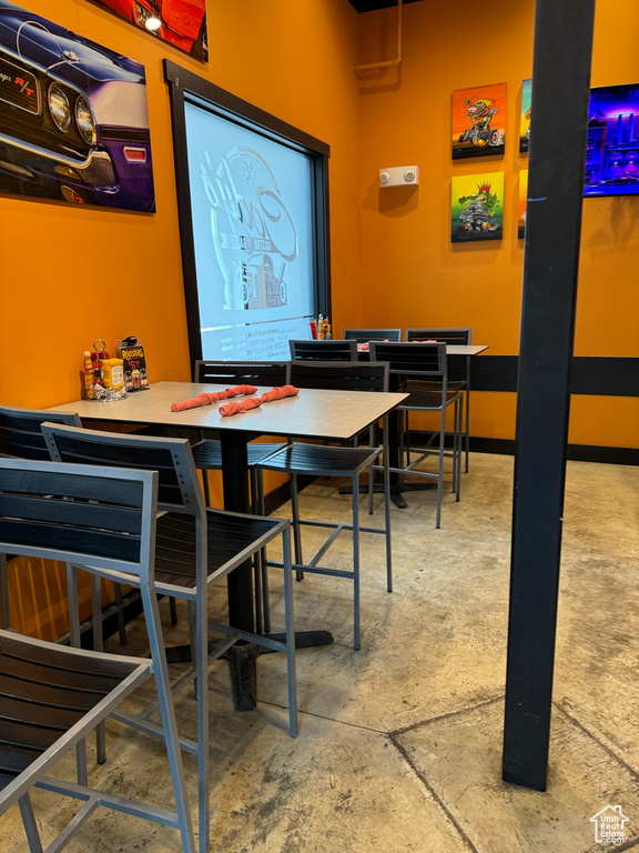 Dining room with concrete flooring and baseboards