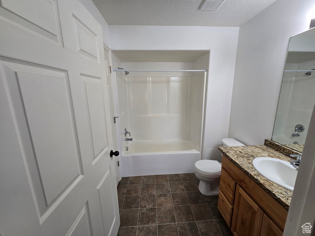 Bathroom with vanity, shower / tub combination, a textured ceiling, toilet, and visible vents