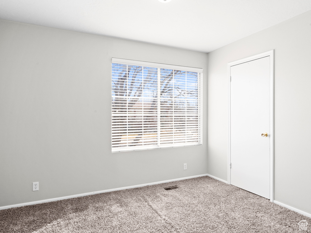 Unfurnished bedroom featuring carpet flooring, visible vents, and baseboards