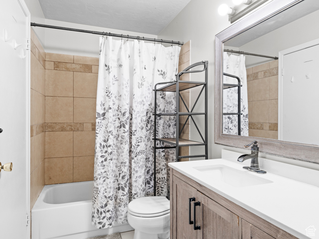 Bathroom featuring shower / bath combo, vanity, and toilet