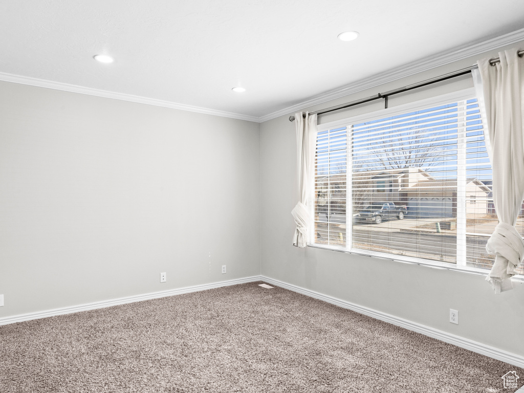 Spare room with carpet floors, baseboards, ornamental molding, and recessed lighting