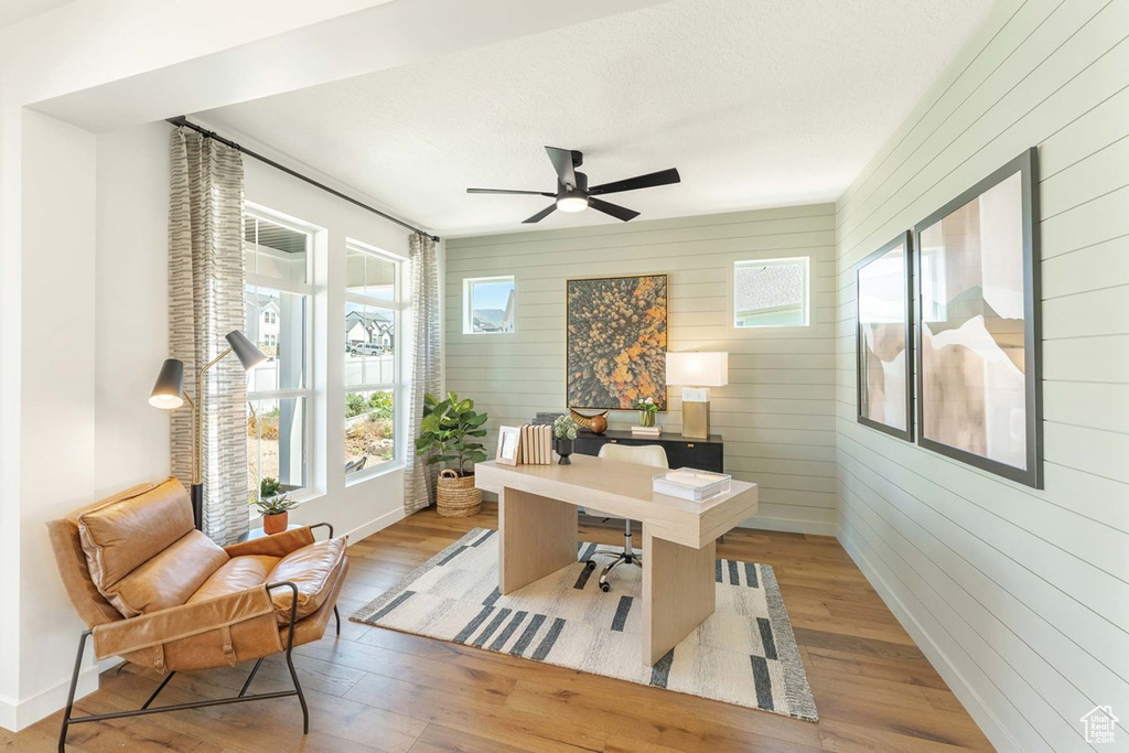Office featuring wood finished floors, wood walls, and a ceiling fan