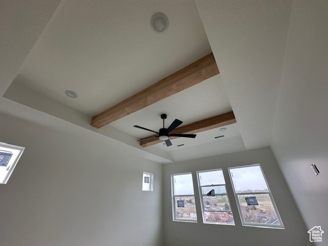 Room details with a ceiling fan and beam ceiling