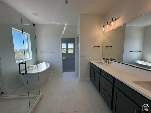 Bathroom with a soaking tub, a sink, double vanity, and plenty of natural light