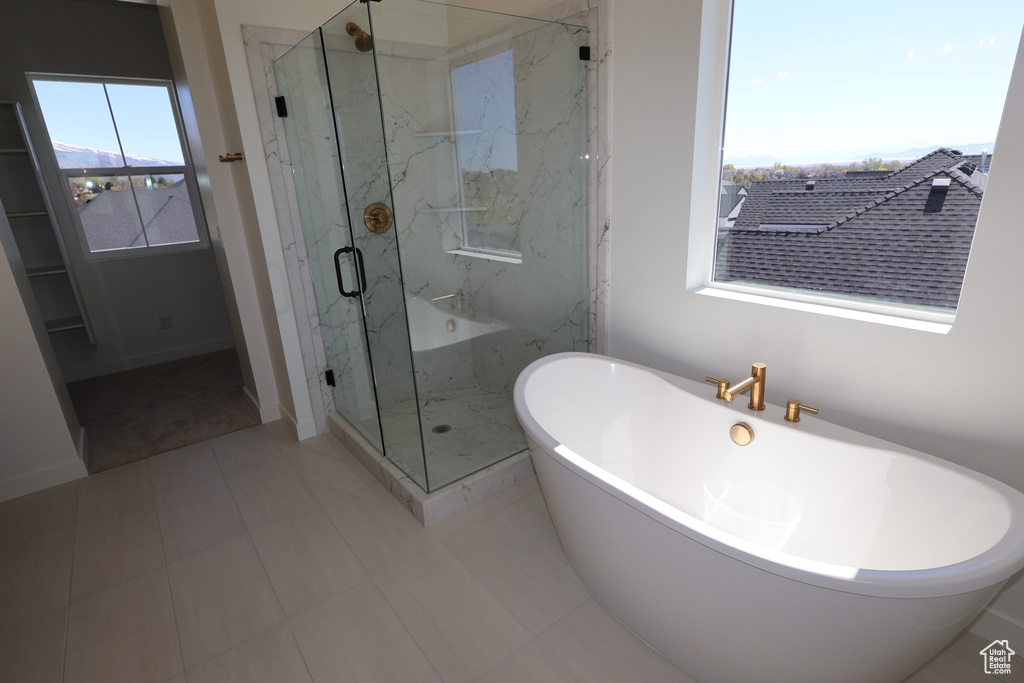 Full bath featuring baseboards, a marble finish shower, tile patterned flooring, and a freestanding bath