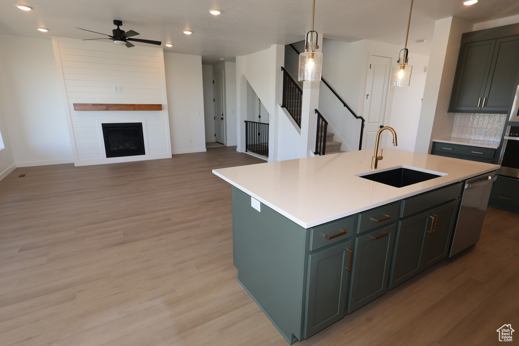Kitchen with light countertops, a sink, recessed lighting, and ceiling fan