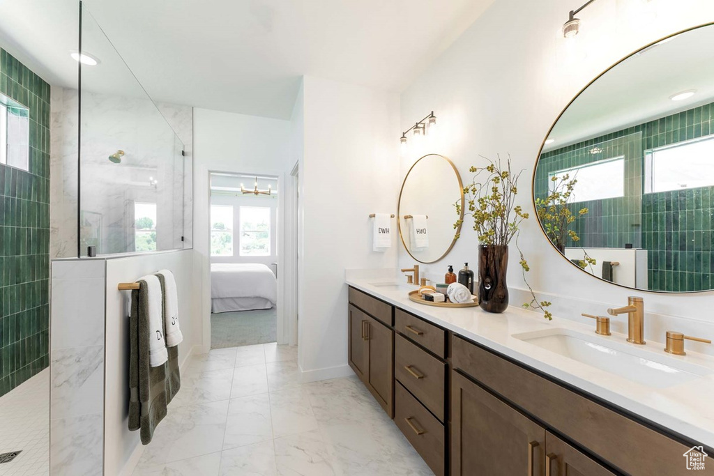 Bathroom with marble finish floor, double vanity, connected bathroom, a sink, and walk in shower