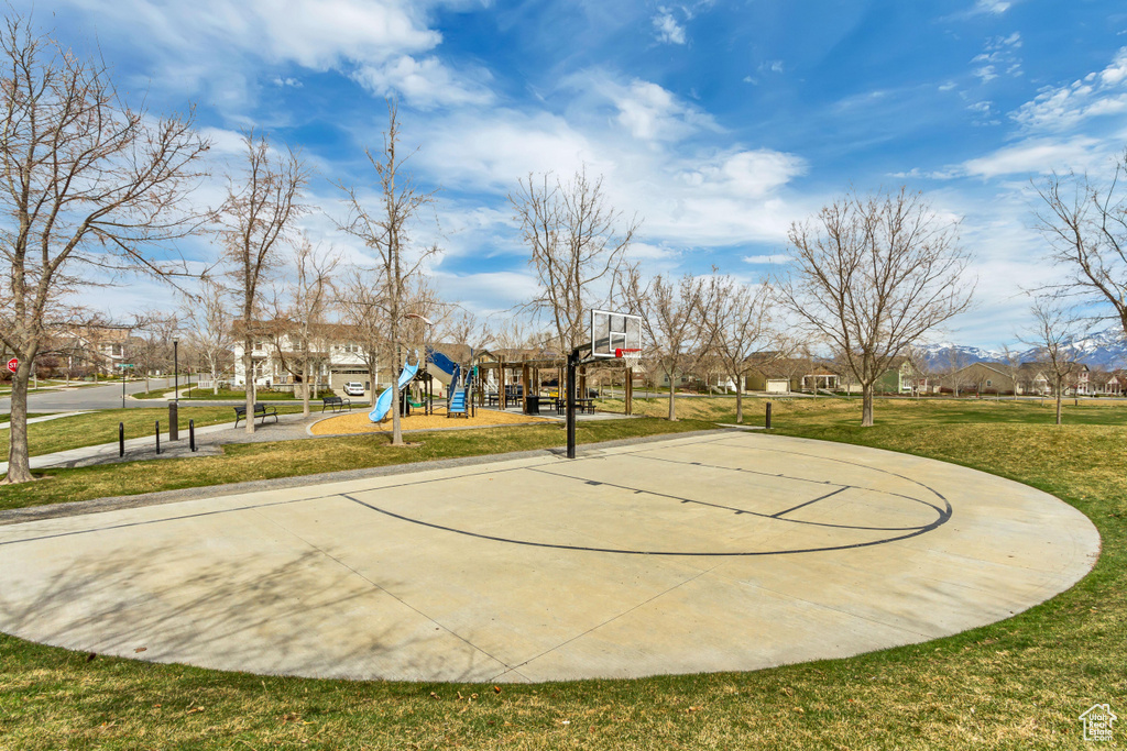 View of basketball court featuring playground community, community basketball court, and a lawn
