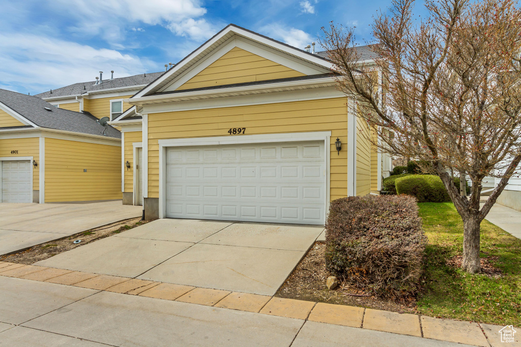 View of front of home with a garage and concrete driveway