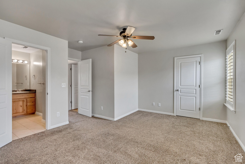Unfurnished bedroom with visible vents, ensuite bathroom, a ceiling fan, light carpet, and baseboards