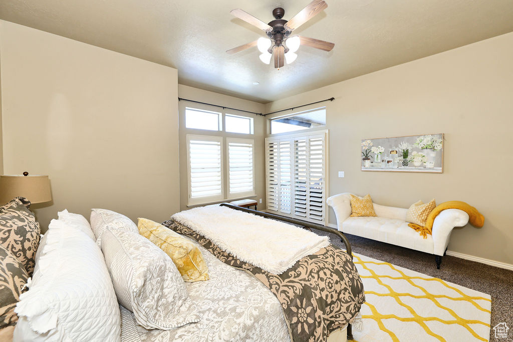 Carpeted bedroom featuring a ceiling fan and baseboards