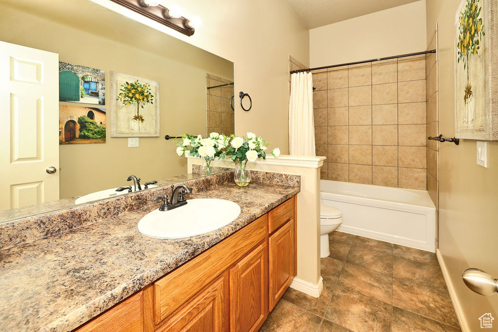 Bathroom with toilet, baseboards, shower / bath combo with shower curtain, and vanity