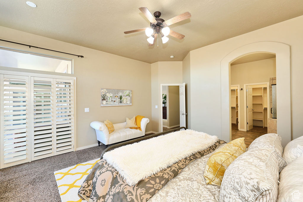 Carpeted bedroom featuring access to exterior, arched walkways, ceiling fan, a textured ceiling, and baseboards
