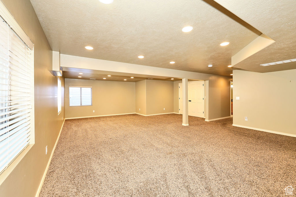 Below grade area with recessed lighting, carpet flooring, a textured ceiling, and baseboards