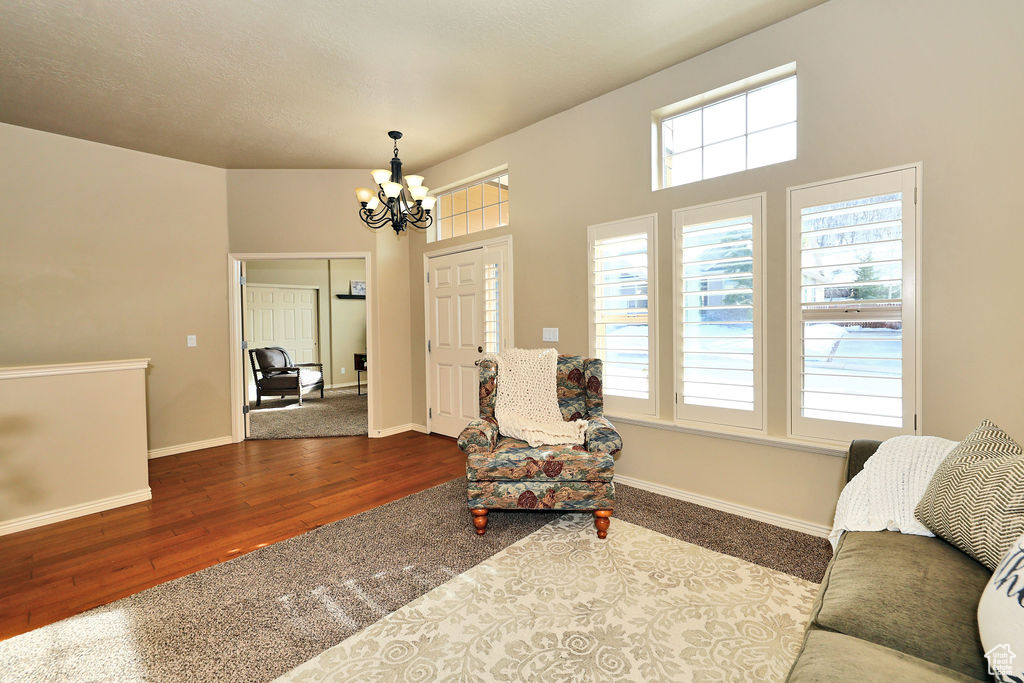 Living area with an inviting chandelier, baseboards, and wood finished floors