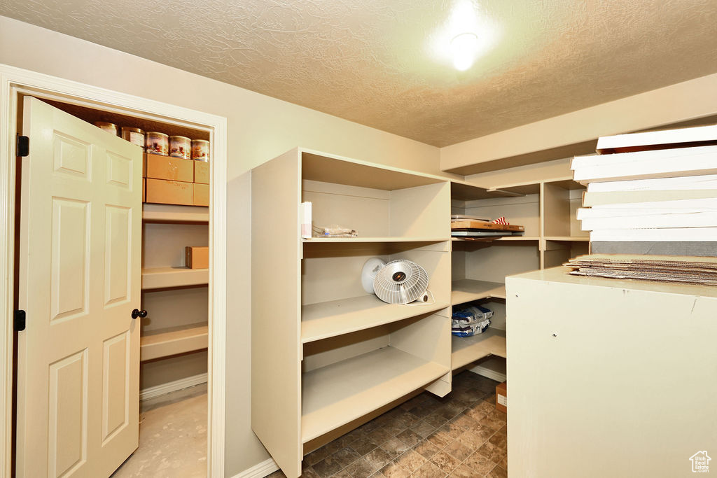 Spacious closet featuring stone finish floor