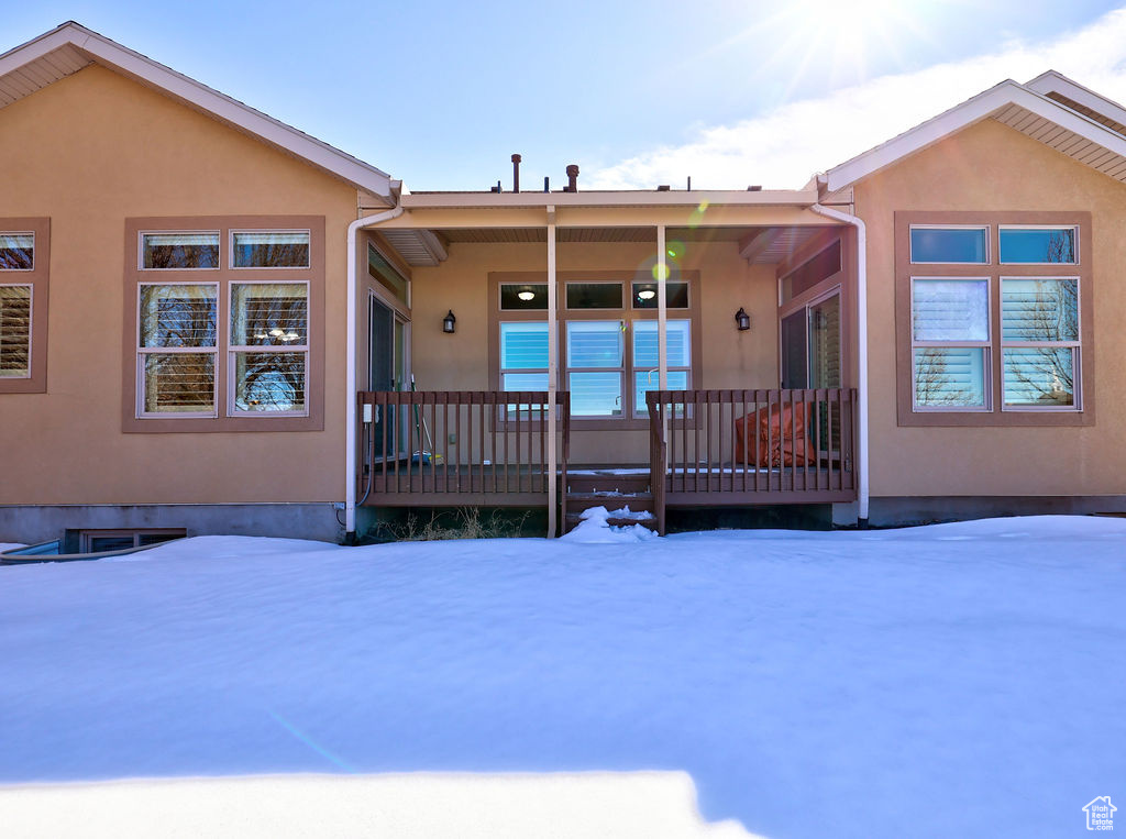 Snow covered property featuring stucco siding