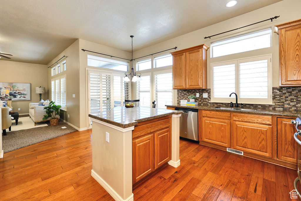 Kitchen featuring pendant lighting, visible vents, appliances with stainless steel finishes, a sink, and a kitchen island