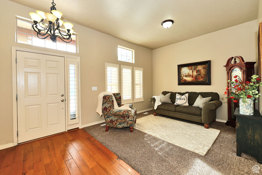 Entrance foyer featuring dark wood-style floors, baseboards, and a chandelier