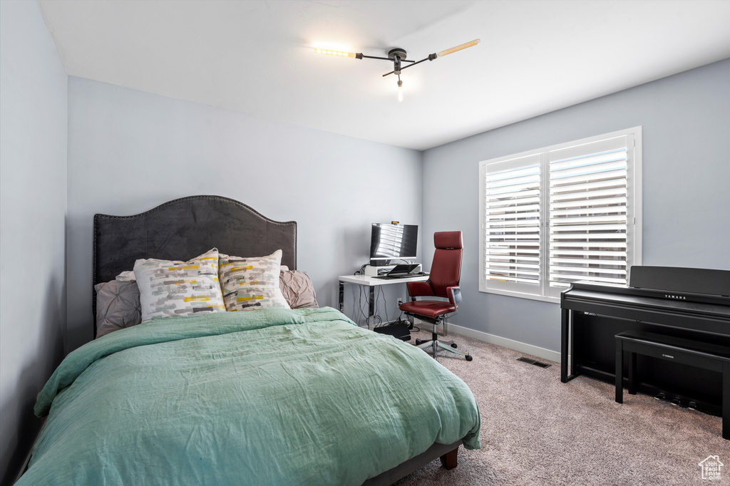 Bedroom featuring carpet flooring, visible vents, and baseboards