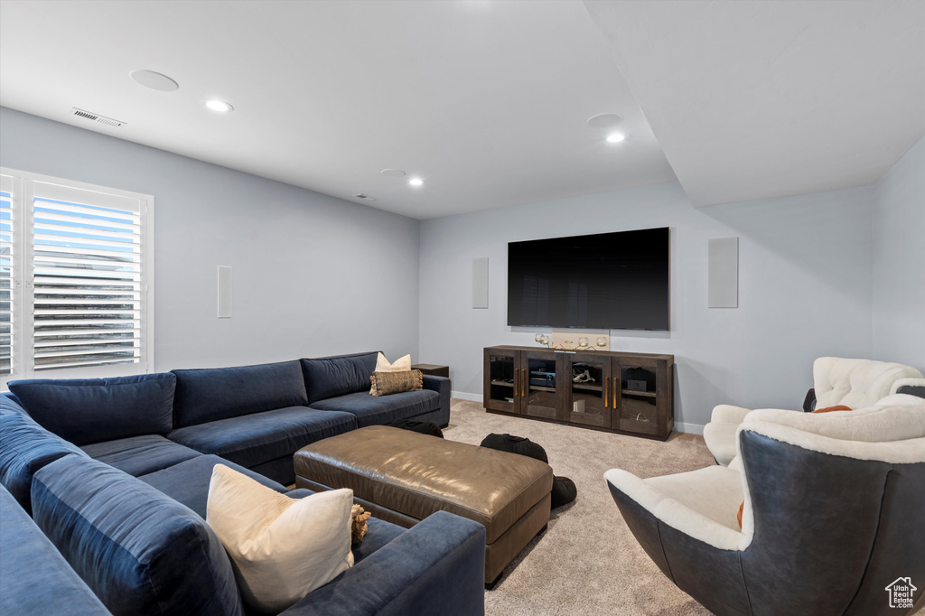 Living area with light carpet, visible vents, baseboards, and recessed lighting