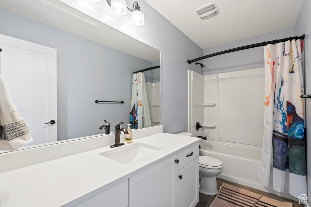 Bathroom with tile patterned flooring, toilet, vanity, visible vents, and shower / tub combo with curtain