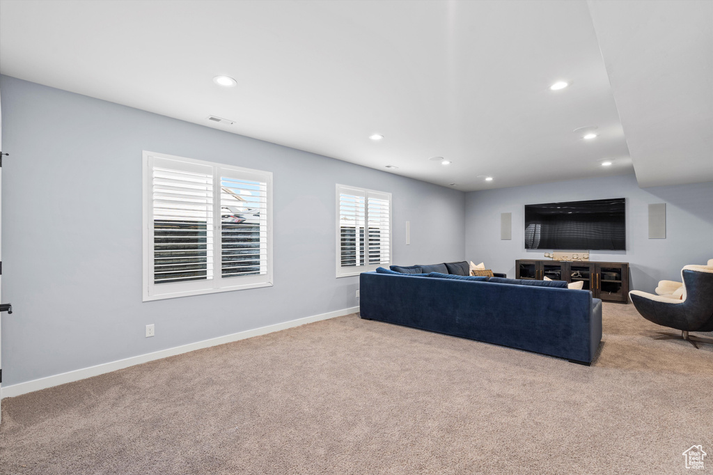 Living area with recessed lighting, visible vents, baseboards, and light colored carpet