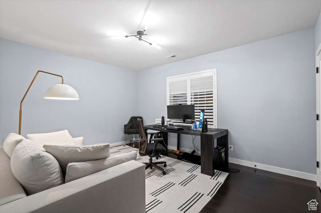 Office space featuring visible vents, baseboards, and wood finished floors