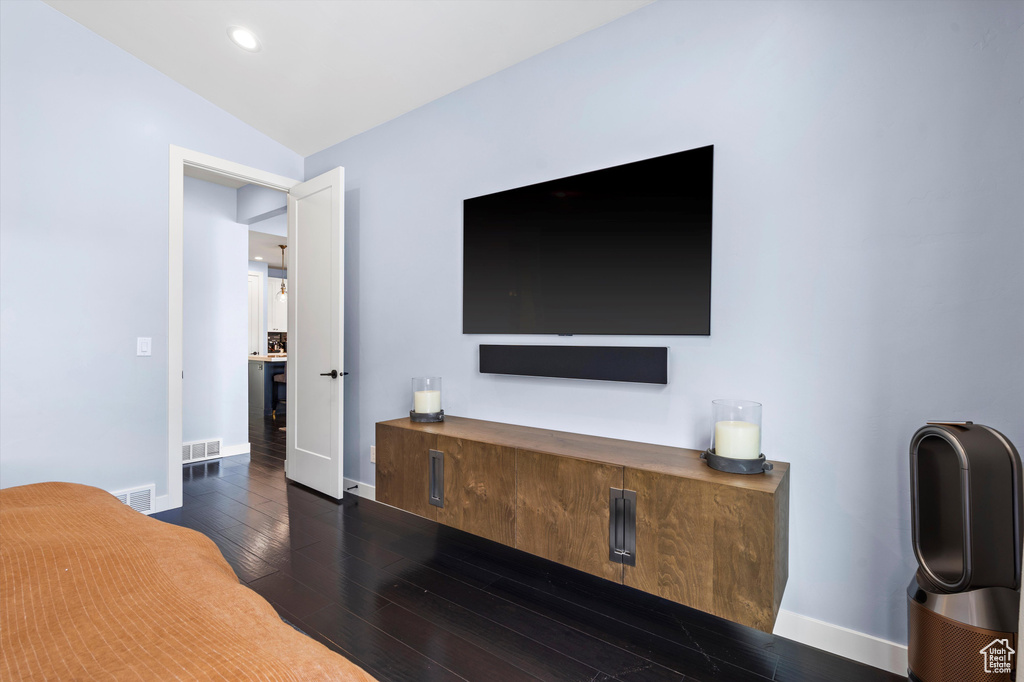 Bedroom featuring dark wood-type flooring, visible vents, and baseboards