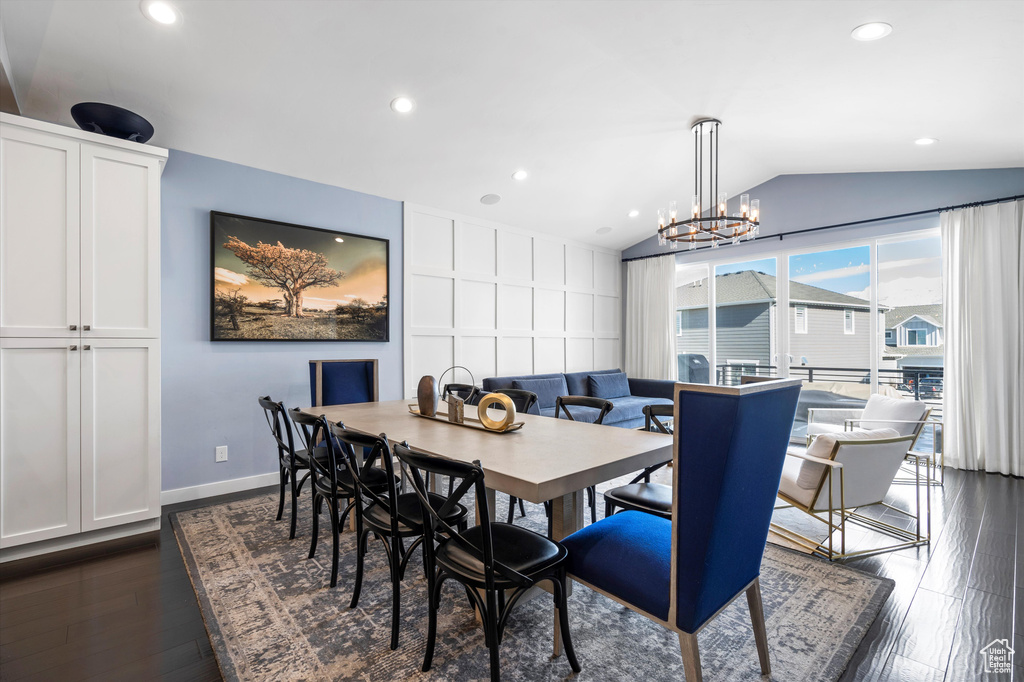 Dining room with lofted ceiling, recessed lighting, a notable chandelier, dark wood-style flooring, and baseboards