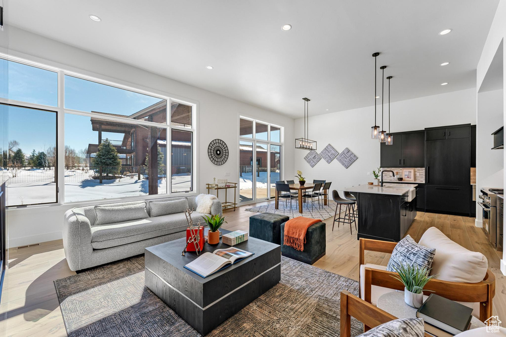 Living area with light wood-style floors, recessed lighting, plenty of natural light, and baseboards