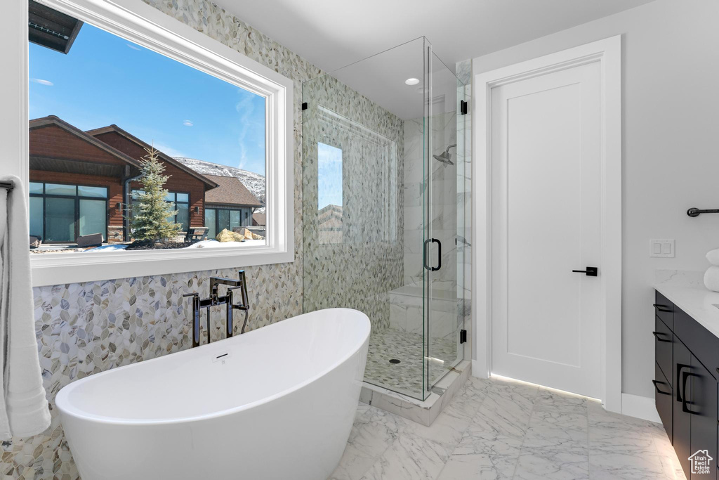 Full bath with a stall shower, marble finish floor, a freestanding bath, and vanity