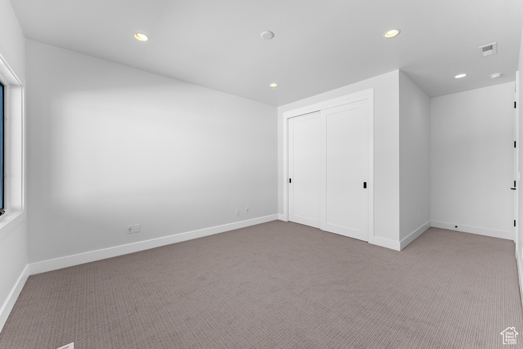 Unfurnished bedroom featuring baseboards, carpet, visible vents, and recessed lighting