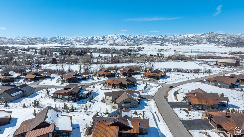 Snowy aerial view featuring a residential view and a mountain view