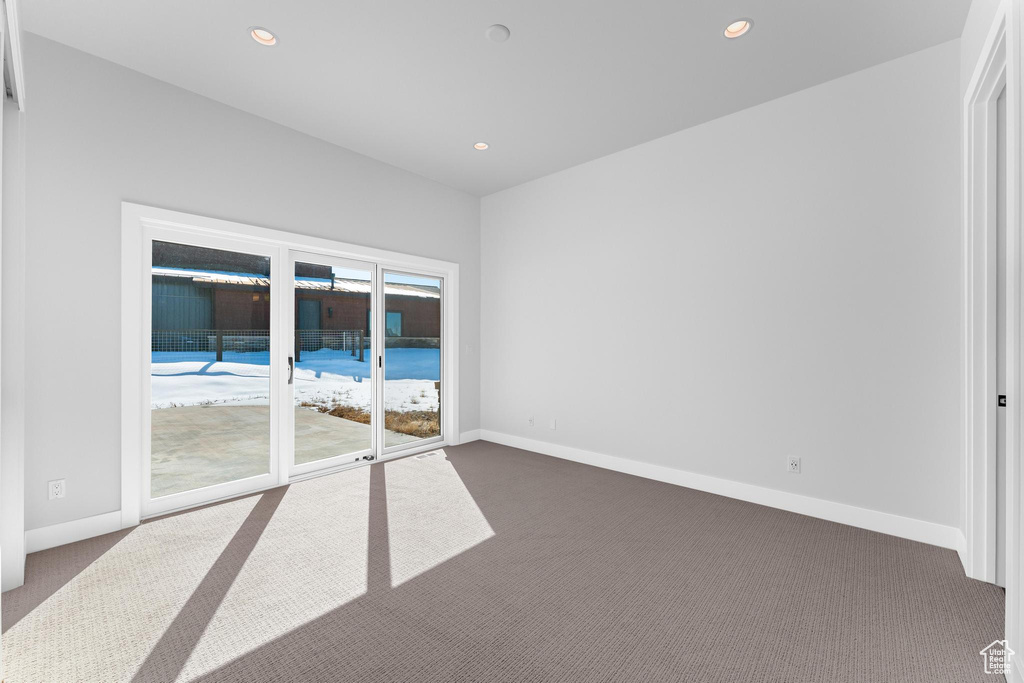 Unfurnished room featuring baseboards, dark colored carpet, and recessed lighting
