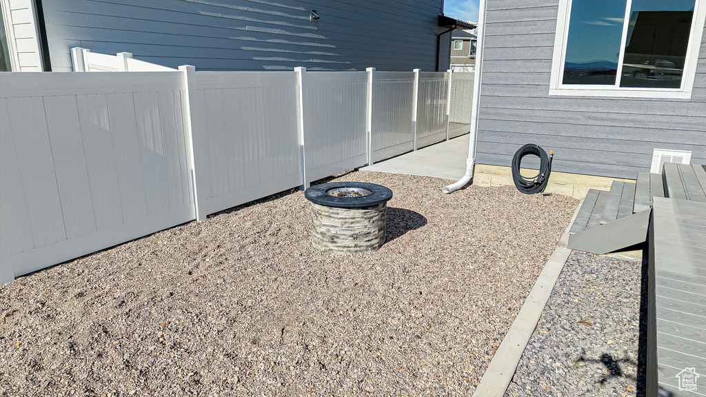 Exterior space featuring an outdoor fire pit and fence