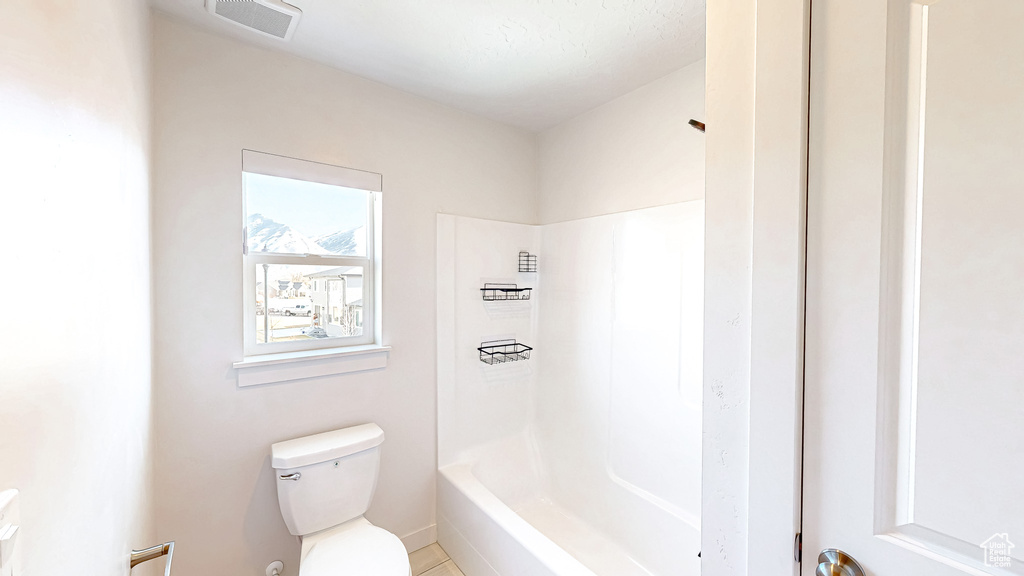 Bathroom with toilet, shower / washtub combination, and visible vents