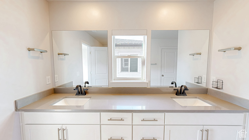 Full bath featuring double vanity and a sink