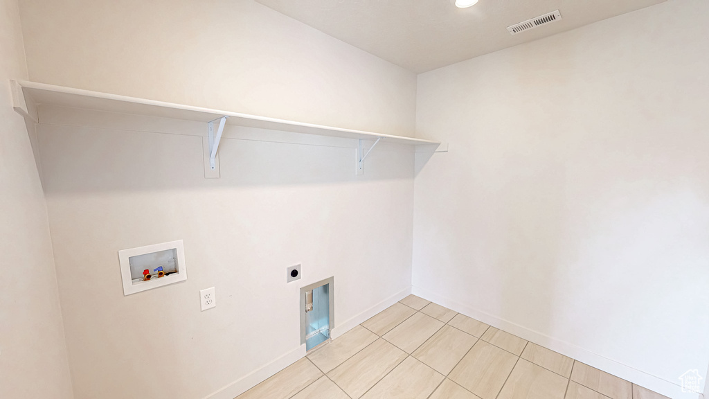 Clothes washing area with washer hookup, light tile patterned floors, visible vents, hookup for an electric dryer, and laundry area