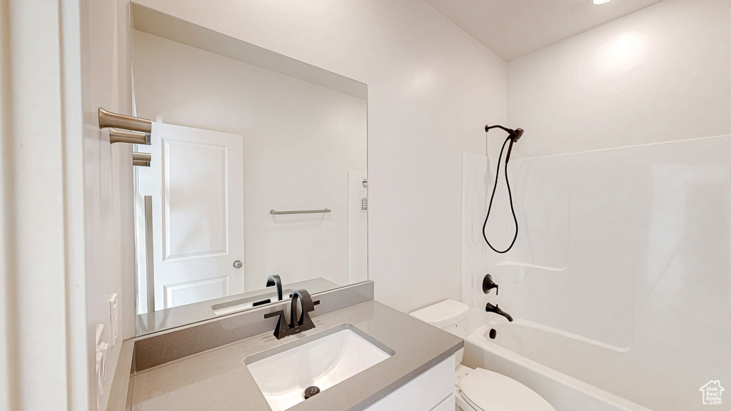 Bathroom with toilet, washtub / shower combination, and vanity