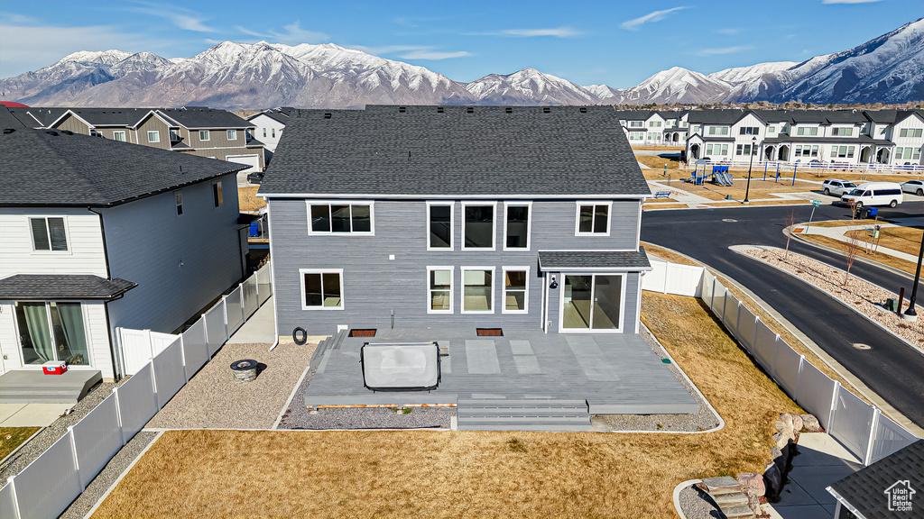 Rear view of property featuring a shingled roof, a residential view, a fenced backyard, and a mountain view